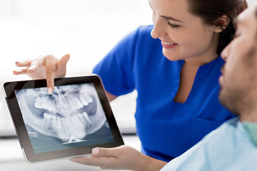 dental assistant showing patient dental xrays at the dentist office